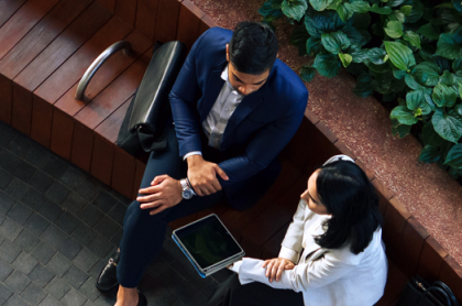 two business people talking on a bench